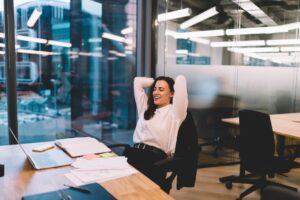 Cheerful woman resting on chair in office